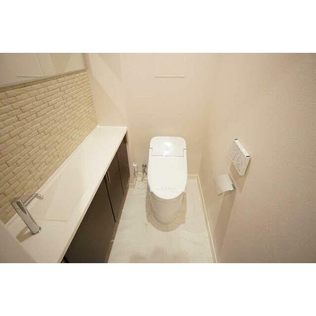 トイレの様子です。壁付リモコンの洗浄機能付き便座です。手洗機もあります。(内装)